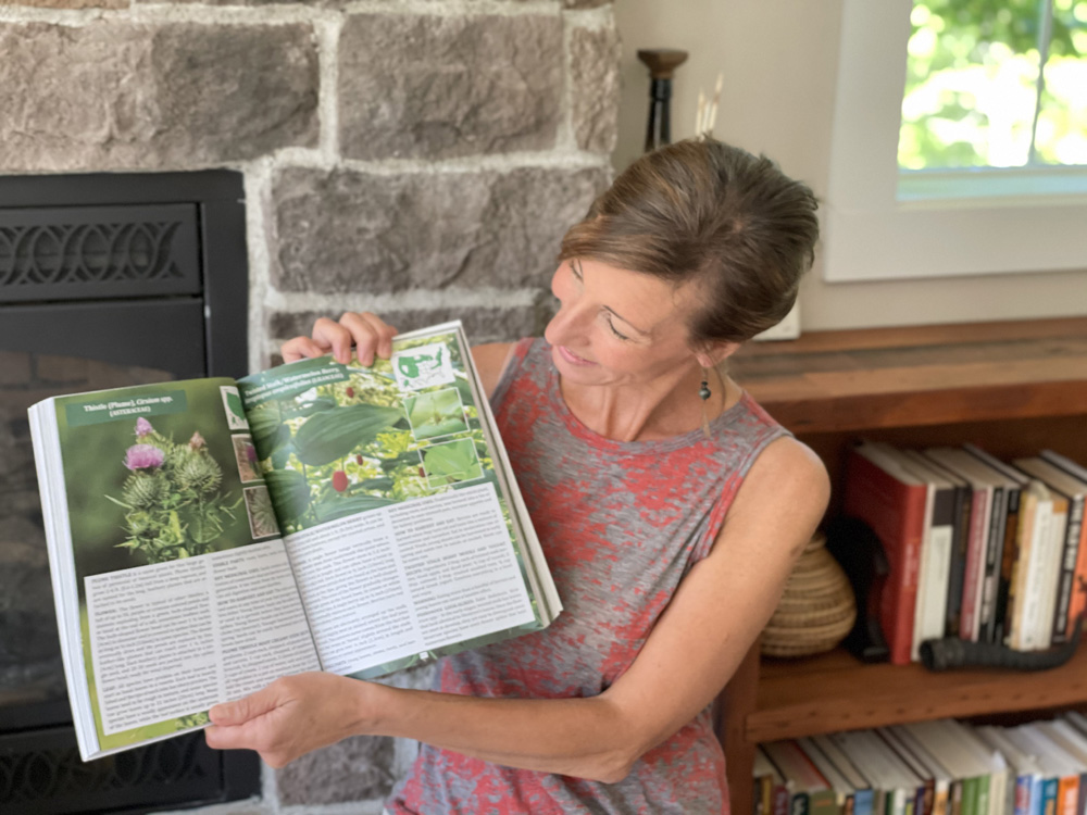 Nicole Apelian holding open her Foraging Guide