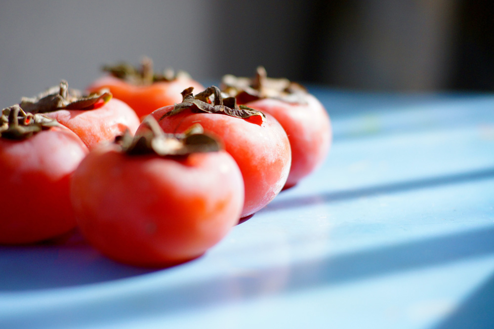 persimmon fruits on a blue counter